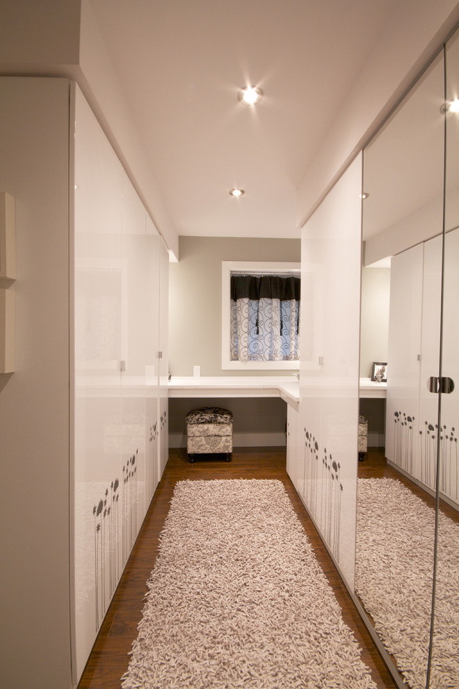 Design ideas for a mid-sized contemporary women's dressing room in Montreal with flat-panel cabinets, white cabinets, dark hardwood floors and brown floor.