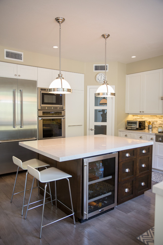 This is an example of a large contemporary u-shaped eat-in kitchen in San Diego with a double-bowl sink, beaded inset cabinets, light wood cabinets, limestone benchtops, multi-coloured splashback, glass tile splashback, stainless steel appliances, light hardwood floors and with island.