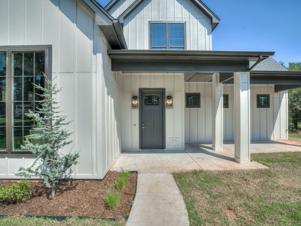 Large rural front door in Oklahoma City with white walls, concrete flooring, a single front door and a grey front door.