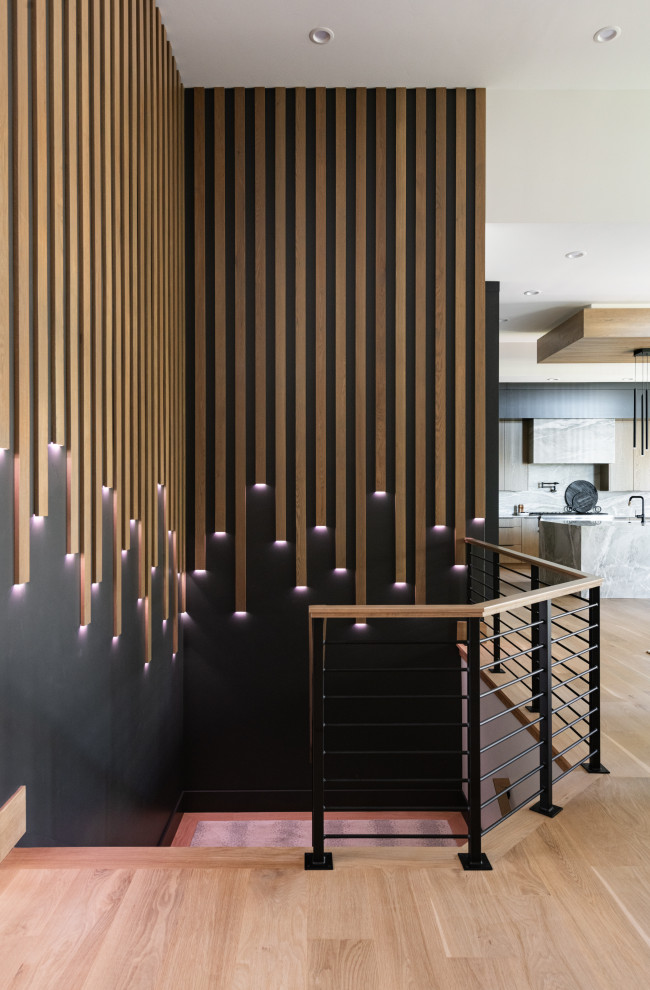 Huge minimalist carpeted u-shaped metal railing and wall paneling staircase photo in Salt Lake City with carpeted risers