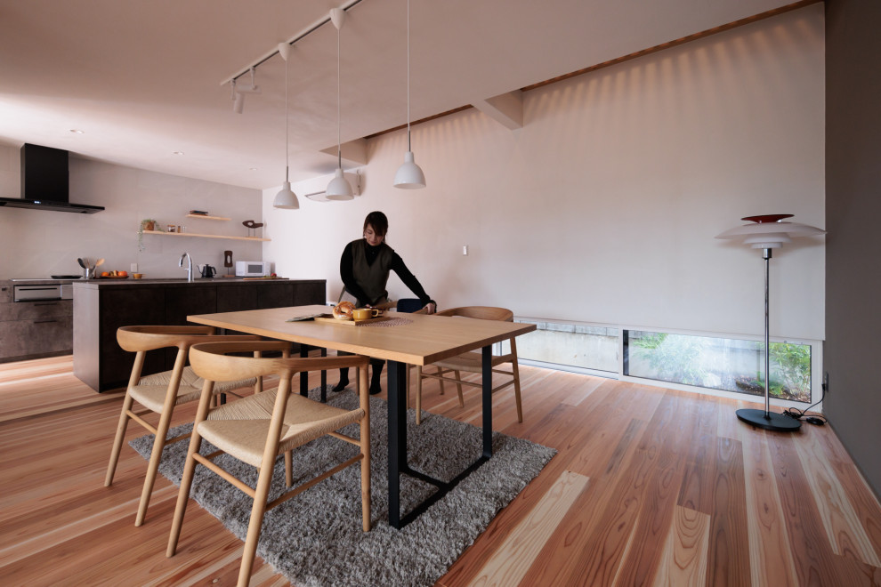 Réalisation d'une salle à manger vintage de taille moyenne avec un mur gris et un sol en bois brun.