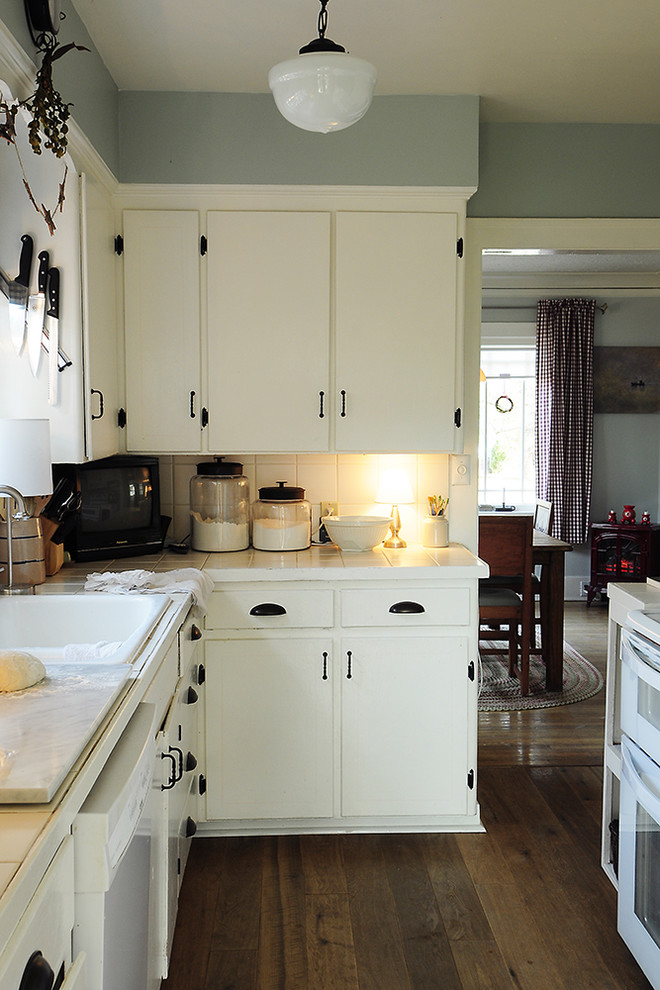Photo of a traditional kitchen in Portland with a drop-in sink, tile benchtops and white appliances.