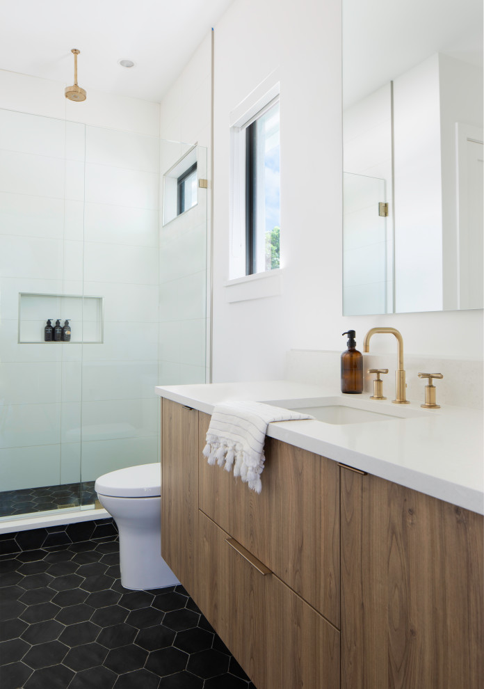 Design ideas for a mid-sized contemporary kids bathroom in Miami with flat-panel cabinets, medium wood cabinets, a two-piece toilet, ceramic tile, white walls, ceramic floors, an undermount sink, engineered quartz benchtops, black floor, a hinged shower door, white benchtops, a niche, a single vanity and a floating vanity.