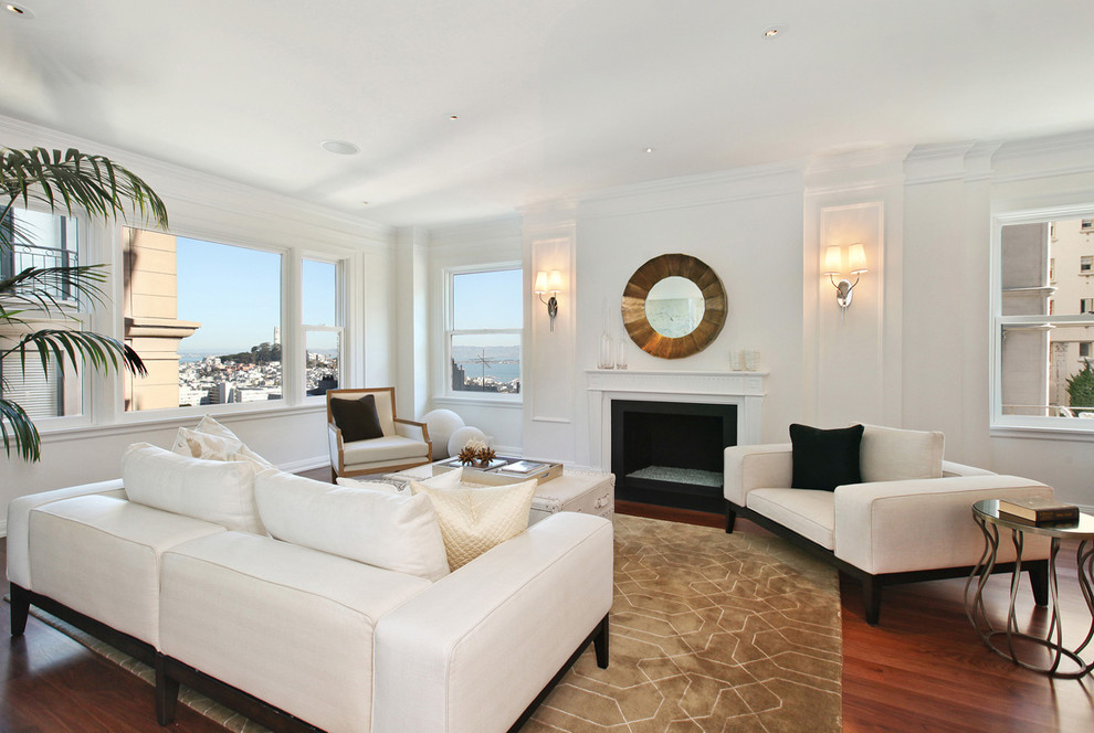 Transitional living room in San Francisco with white walls, dark hardwood floors and a standard fireplace.