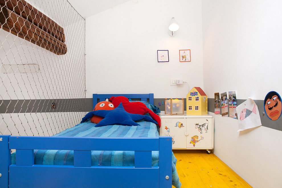 Inspiration for a small modern gender-neutral kids' bedroom for kids 4-10 years old in Bologna with white walls.