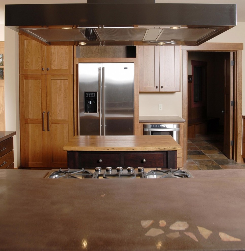 Mid-sized arts and crafts l-shaped separate kitchen in Denver with an undermount sink, shaker cabinets, medium wood cabinets, concrete benchtops, brown splashback, slate splashback, stainless steel appliances, slate floors, multiple islands, brown floor and beige benchtop.