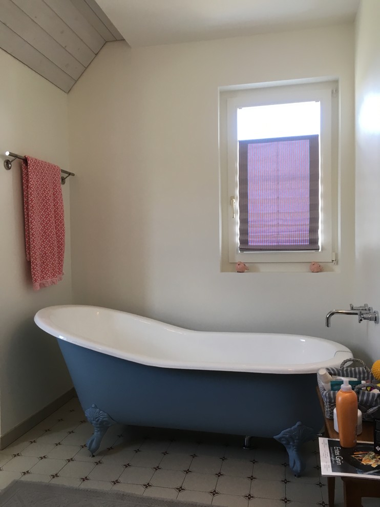 Inredning av ett lantligt badrum, med ett badkar med tassar