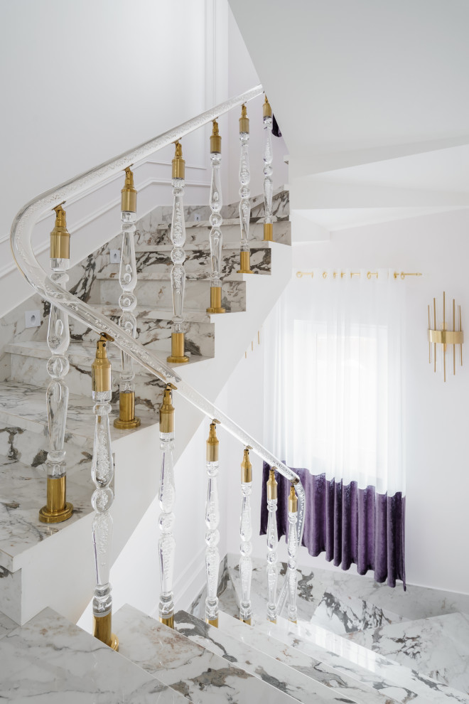 На фото: изогнутая лестница среднего размера в стиле неоклассика (современная классика) с ступенями из плитки, подступенками из плитки, стеклянными перилами и обоями на стенах с