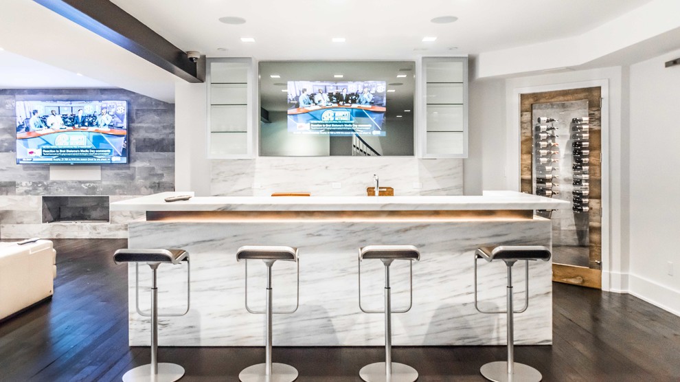 Large modern galley seated home bar in New York with an undermount sink, marble benchtops, white splashback, stone slab splashback and dark hardwood floors.