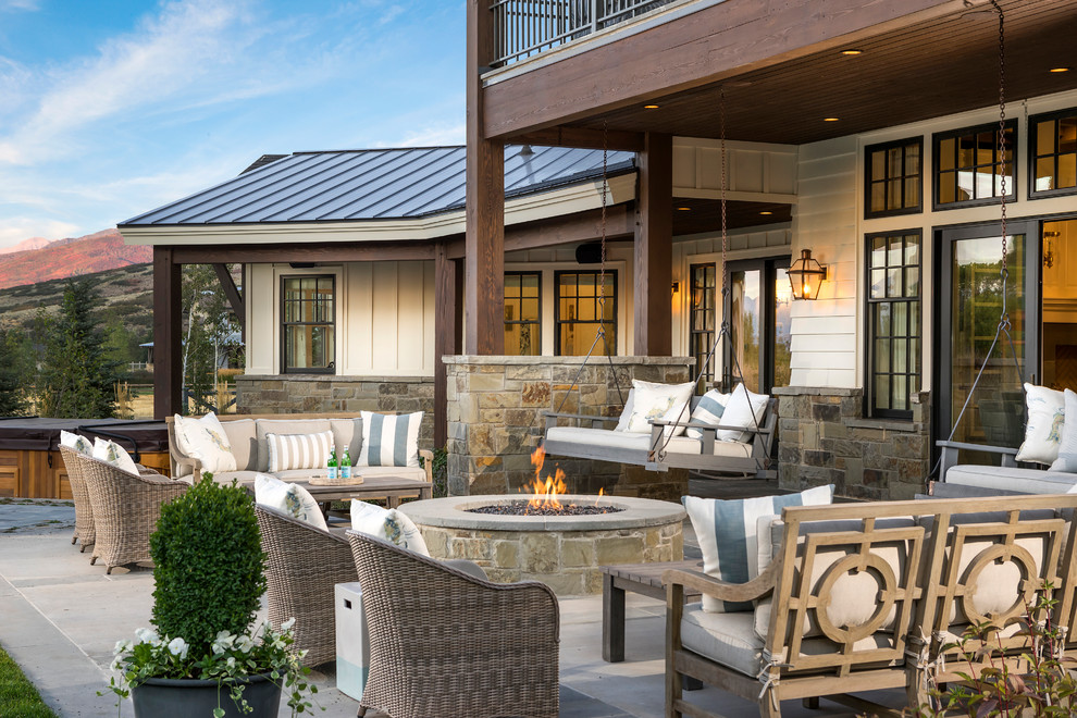 This is an example of a country patio in Salt Lake City with a fire feature and a roof extension.