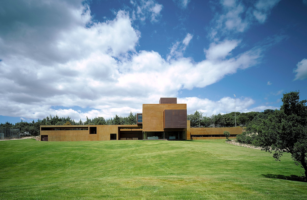 Expansive contemporary split-level concrete brown exterior in Madrid with a flat roof.
