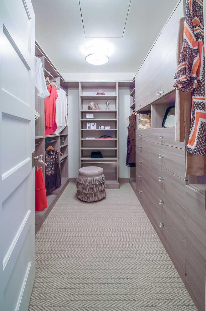 Photo of a mid-sized beach style women's walk-in wardrobe in Minneapolis with flat-panel cabinets, light wood cabinets and carpet.