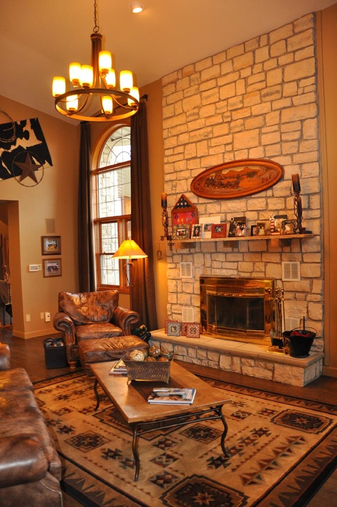 Photo of a large country enclosed family room in Other with beige walls, medium hardwood floors, a standard fireplace, a stone fireplace surround, no tv and brown floor.