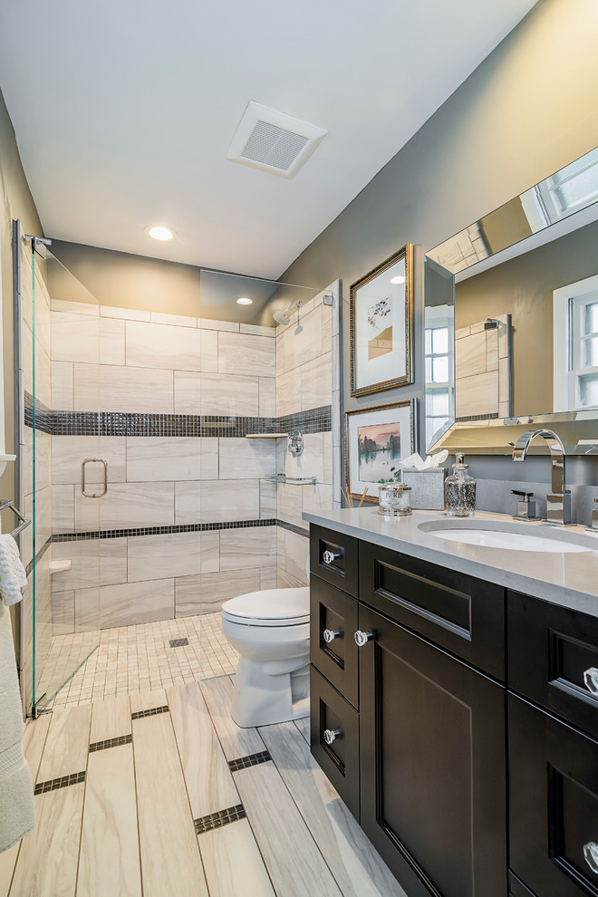 Inspiration for a mid-sized transitional master gray tile and porcelain tile porcelain tile walk-in shower remodel in Chicago with shaker cabinets, dark wood cabinets, a one-piece toilet, gray walls, a drop-in sink and quartz countertops