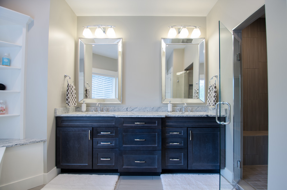 Mid-sized transitional master alcove shower photo with shaker cabinets, dark wood cabinets, gray walls, an undermount sink, marble countertops and a hinged shower door