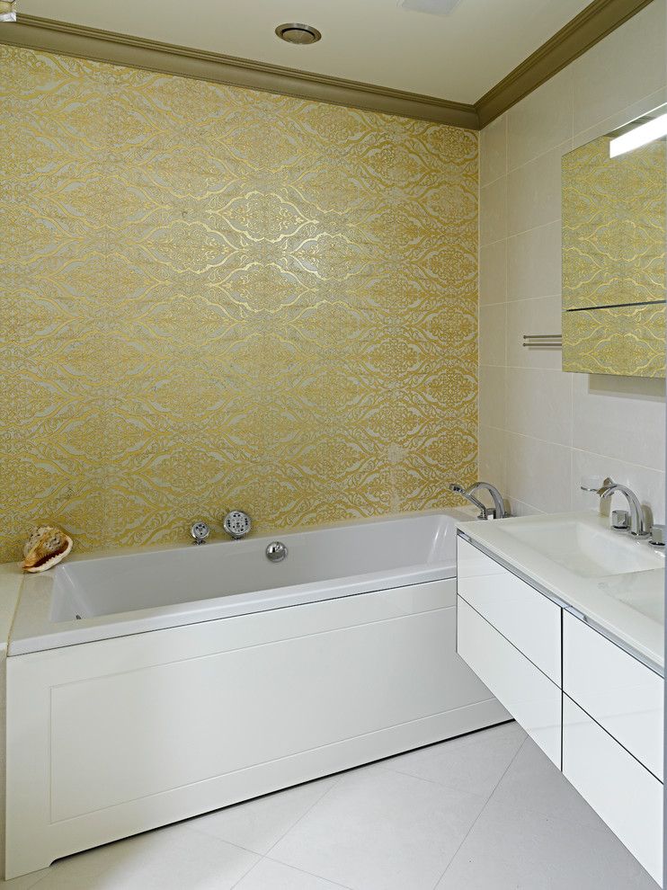 This is an example of a contemporary master bathroom in Moscow with flat-panel cabinets, white cabinets, an alcove tub, white tile, yellow tile, a trough sink and white floor.