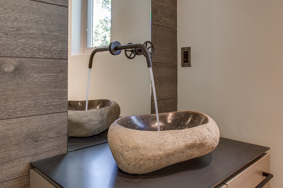 Small modern powder room in Seattle with flat-panel cabinets, brown cabinets, a one-piece toilet, brown tile, porcelain tile, white walls, porcelain floors, a vessel sink and stainless steel benchtops.