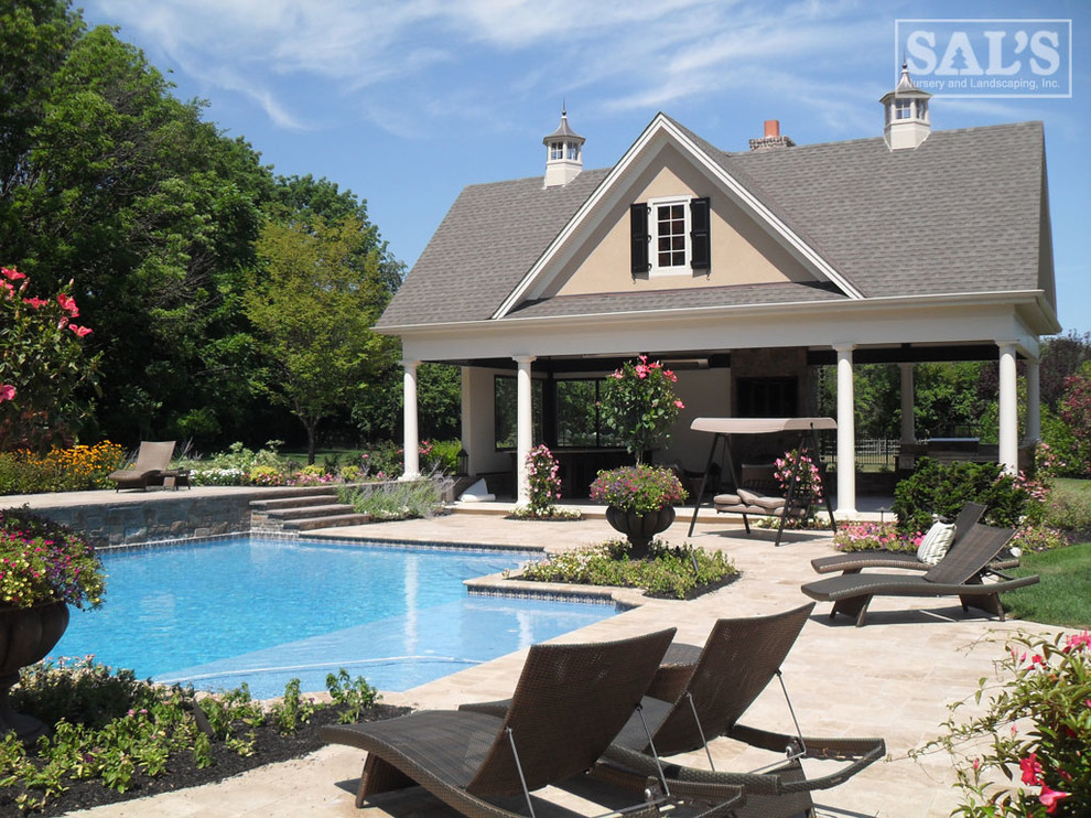 Expansive traditional backyard custom-shaped pool in Philadelphia with natural stone pavers.