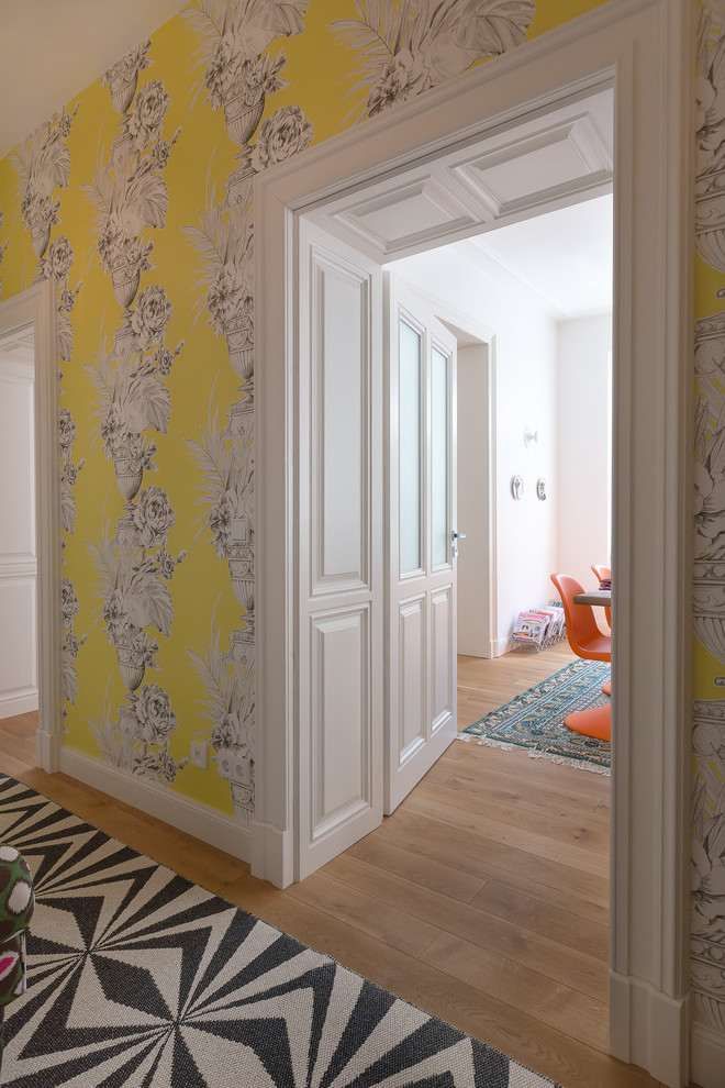 Small contemporary hallway in Cologne with yellow walls, medium hardwood floors and brown floor.