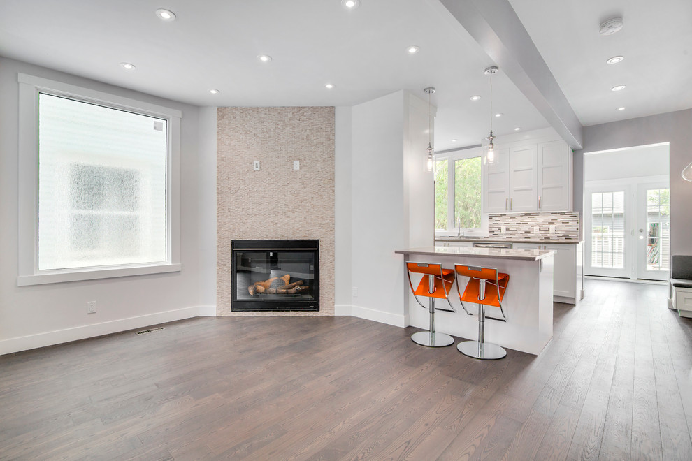 Inspiration for a mid-sized contemporary u-shaped open plan kitchen in Calgary with an undermount sink, shaker cabinets, white cabinets, quartz benchtops, grey splashback, glass tile splashback, stainless steel appliances, dark hardwood floors and a peninsula.