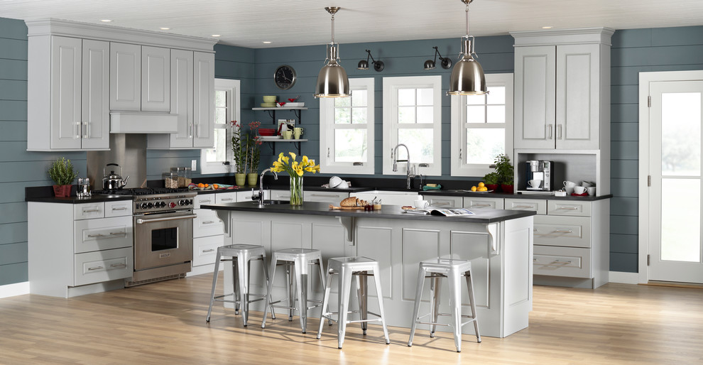 Inspiration for a large transitional l-shaped light wood floor and brown floor kitchen remodel in Orange County with a farmhouse sink, raised-panel cabinets, white cabinets, blue backsplash, wood backsplash, stainless steel appliances and an island