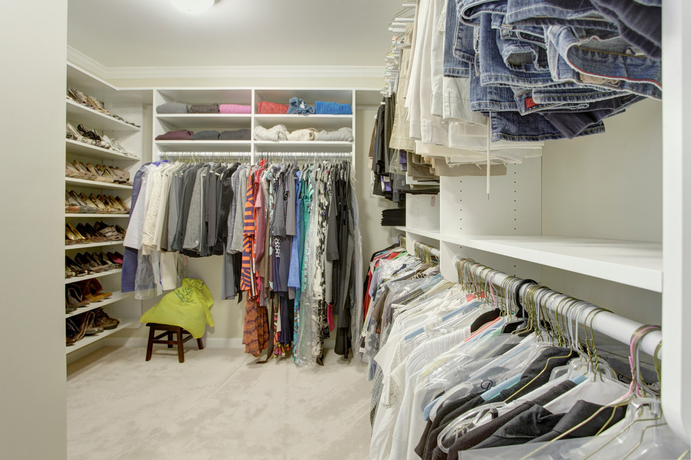 This is an example of a mid-sized traditional gender-neutral walk-in wardrobe in Birmingham with carpet, open cabinets, white cabinets and beige floor.