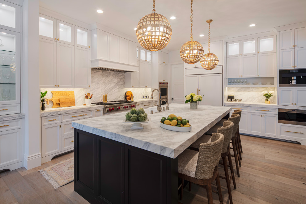 Example of a huge transitional l-shaped light wood floor and beige floor eat-in kitchen design in San Francisco with a farmhouse sink, shaker cabinets, white cabinets, marble countertops, white backsplash, stone slab backsplash, paneled appliances, an island and white countertops