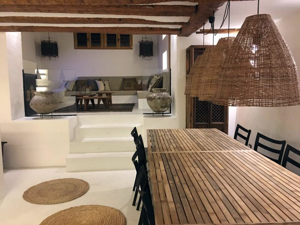 Imagen de comedor mediterráneo de tamaño medio abierto con paredes blancas, suelo de cemento, todas las chimeneas y suelo blanco