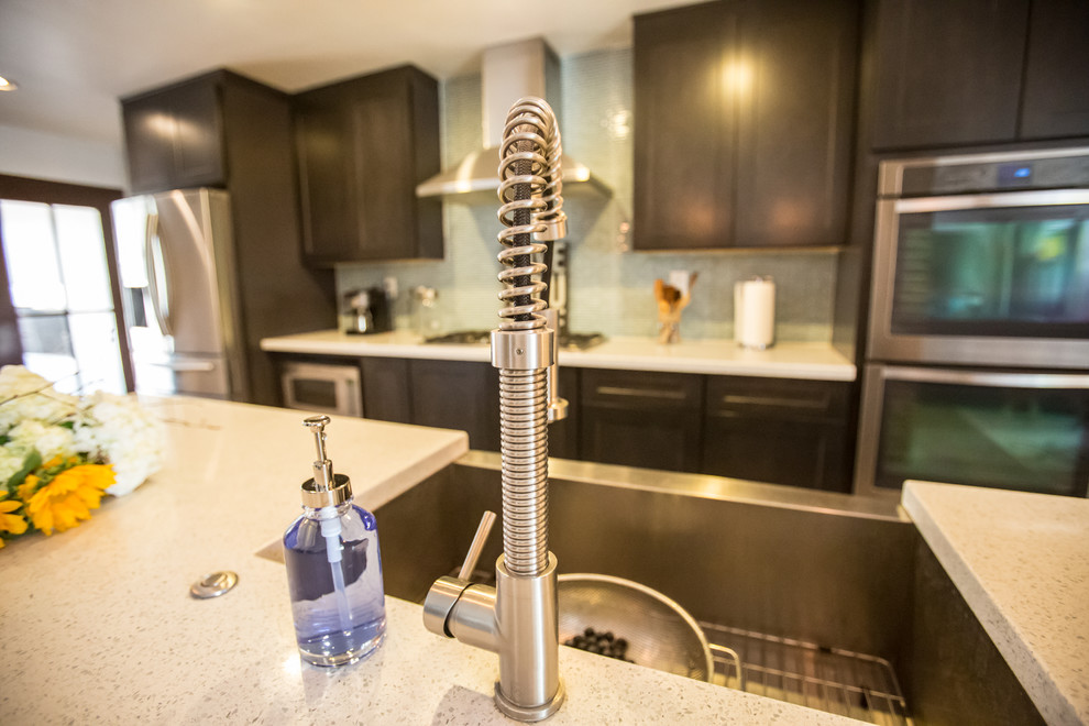 Inspiration for a mid-sized rustic single-wall concrete floor and gray floor open concept kitchen remodel in Phoenix with dark wood cabinets, blue backsplash, stainless steel appliances, an island, an undermount sink, shaker cabinets, quartzite countertops and glass tile backsplash