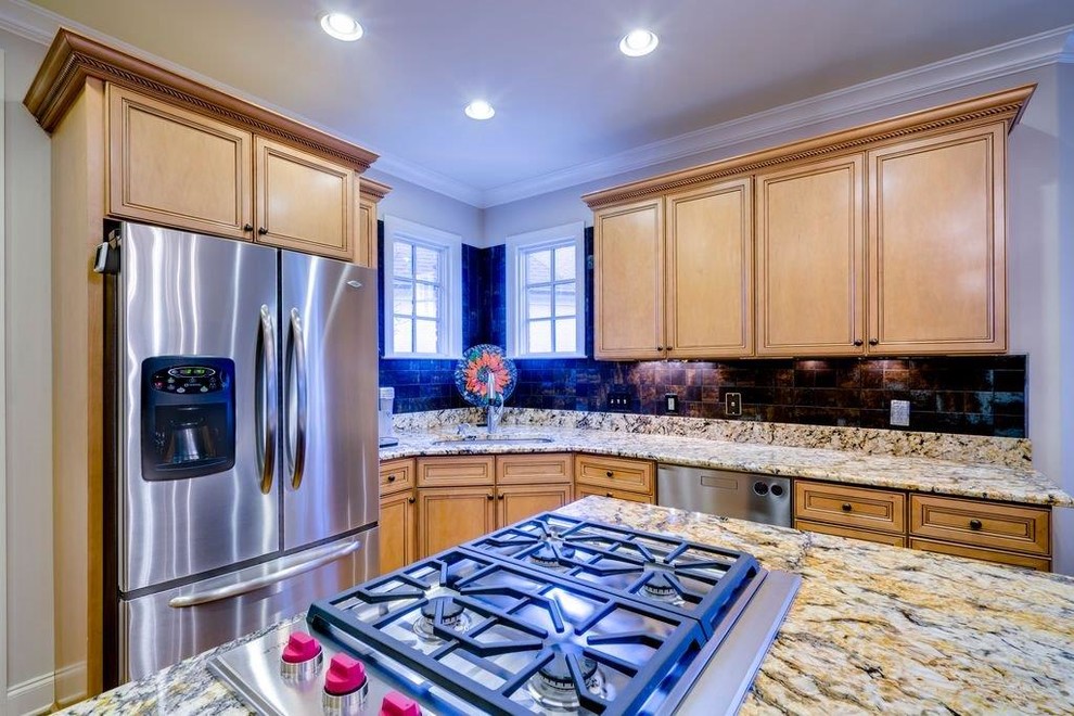 Inspiration for a mid-sized transitional l-shaped eat-in kitchen remodel with an undermount sink, recessed-panel cabinets, light wood cabinets, granite countertops, brown backsplash, stainless steel appliances and an island