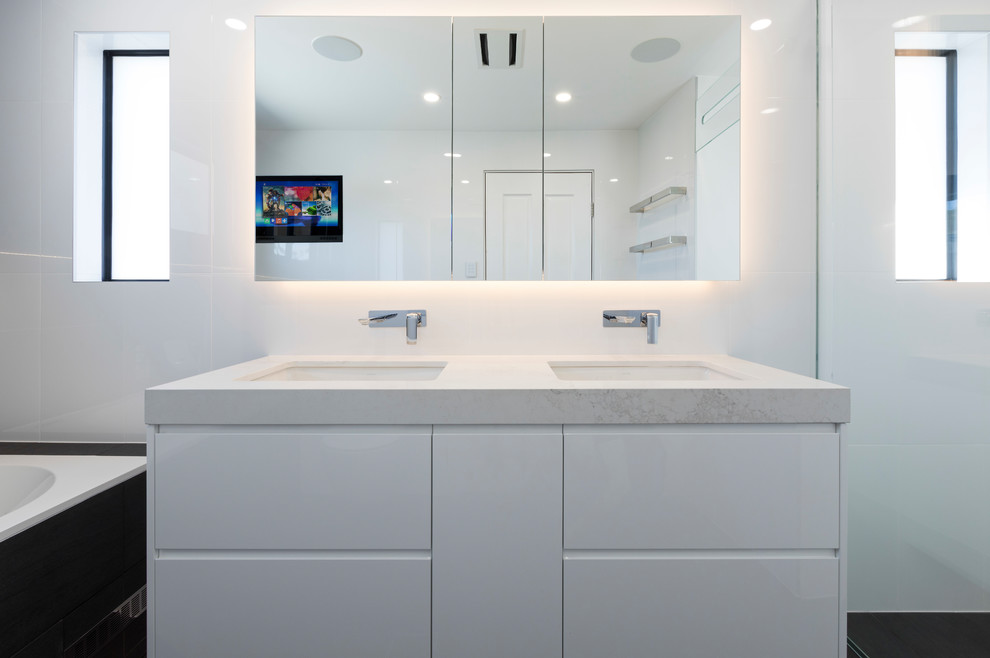 Large contemporary master bathroom in Sydney with beaded inset cabinets, white cabinets, a hot tub, an alcove shower, black and white tile, porcelain tile, engineered quartz benchtops, white benchtops, a double vanity, a floating vanity, white walls, ceramic floors, black floor and a niche.