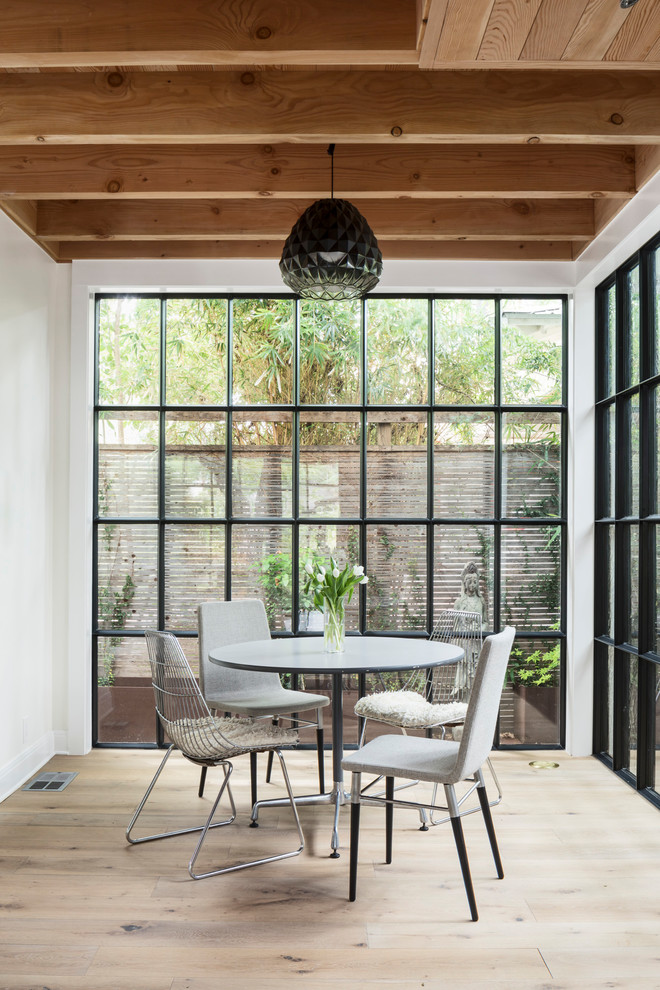 Inspiration for a country dining room in Austin with white walls, light hardwood floors and beige floor.