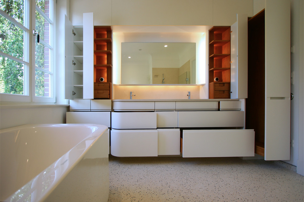 Photo of a mid-sized contemporary bathroom in Hamburg with flat-panel cabinets, white cabinets, white walls and a trough sink.