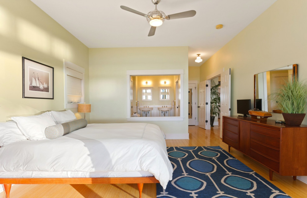 This is an example of a mid-sized beach style master bedroom in Chicago with yellow walls, light hardwood floors and yellow floor.