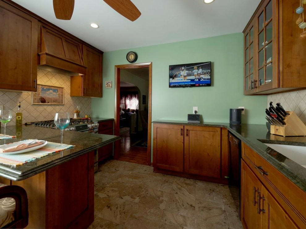 Idée de décoration pour une cuisine américaine chalet de taille moyenne avec des portes de placard marrons, un plan de travail en granite et un plan de travail vert.