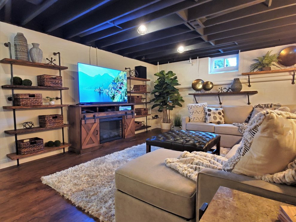Example of a mid-sized urban underground laminate floor, brown floor and exposed beam basement design in Philadelphia with a home theater, white walls, a standard fireplace and a wood fireplace surround