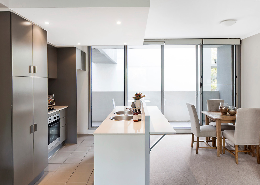 Design ideas for a small contemporary galley eat-in kitchen in Sydney with a double-bowl sink, brown cabinets, stainless steel appliances, ceramic floors and with island.