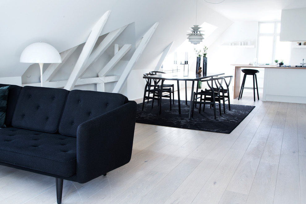 Photo of a small scandinavian open plan dining in Copenhagen with white walls, light hardwood floors and white floor.