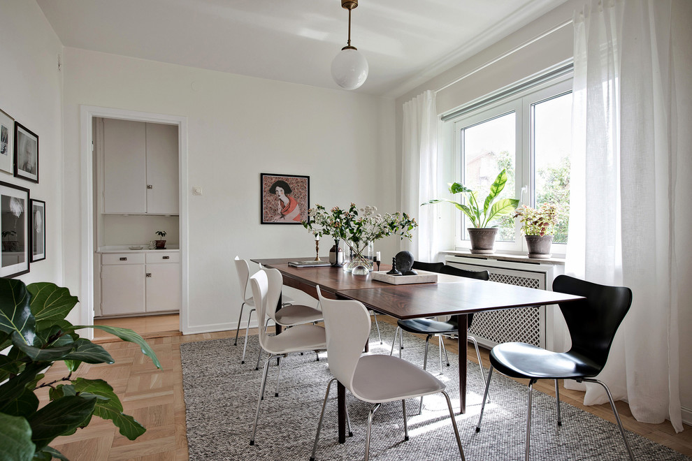 Inspiration for a scandinavian enclosed dining room in Gothenburg with white walls, light hardwood flooring and beige floors.