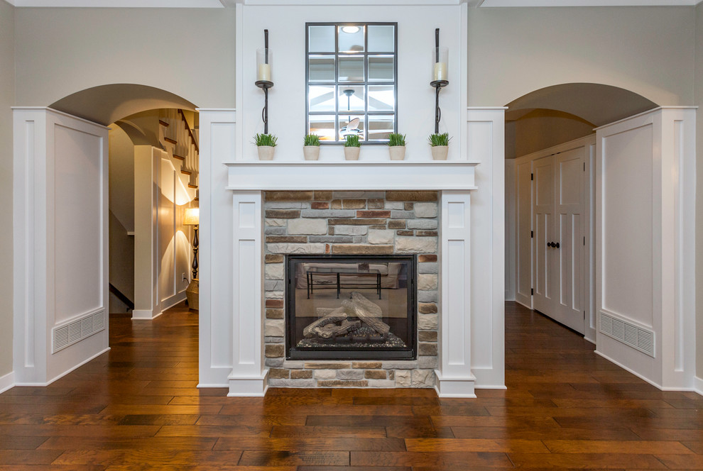 Inspiration for an arts and crafts open concept family room in Other with grey walls, medium hardwood floors, a standard fireplace and a stone fireplace surround.