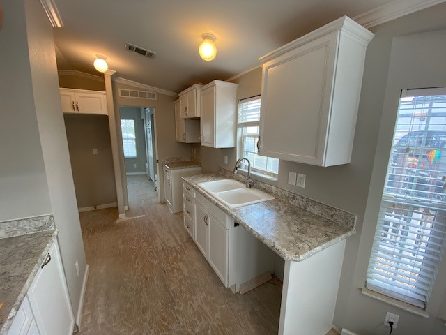 Inspiration for a mid-sized galley kitchen pantry remodel with a double-bowl sink, flat-panel cabinets, white cabinets, laminate countertops, a peninsula and beige countertops