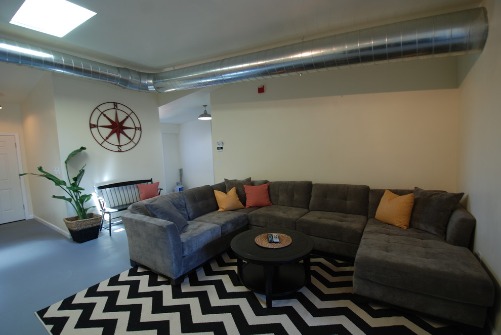 Photo of a mid-sized beach style loft-style living room in Providence with concrete floors and white walls.