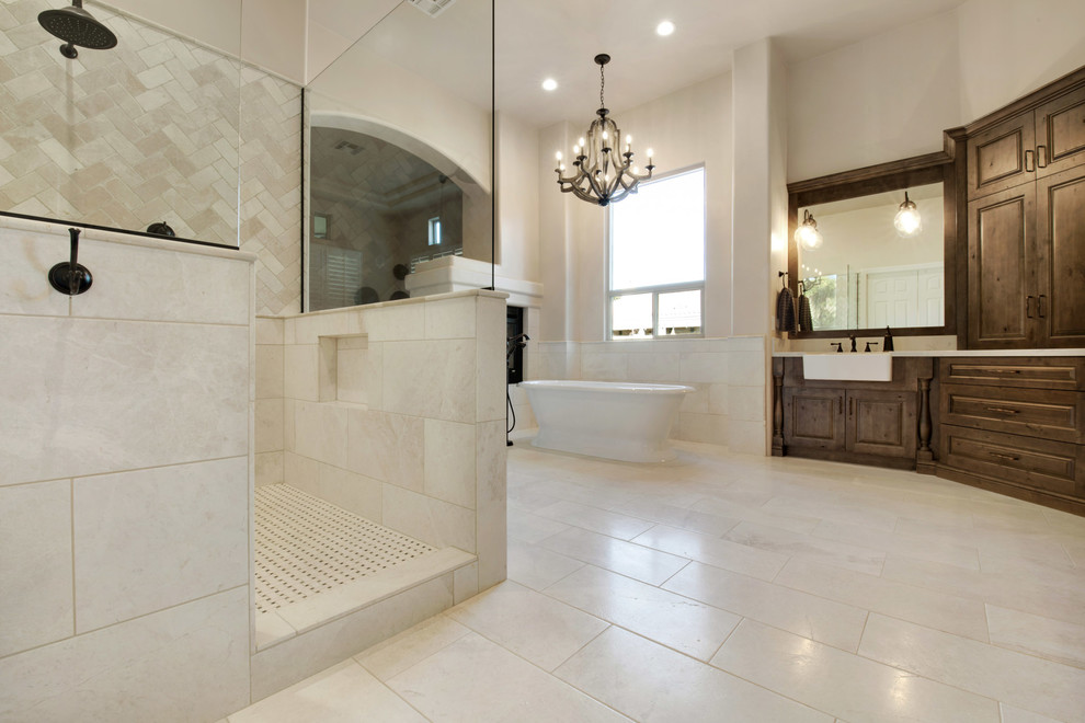 Design ideas for an expansive country master bathroom in Phoenix with raised-panel cabinets, medium wood cabinets, a freestanding tub, a double shower, a one-piece toilet, beige tile, marble, beige walls, travertine floors, a drop-in sink, granite benchtops, white floor and an open shower.
