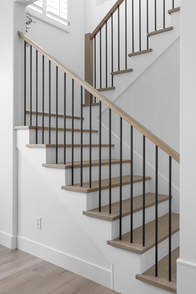 Cette image montre un escalier minimaliste en L de taille moyenne avec des marches en bois et un garde-corps en matériaux mixtes.