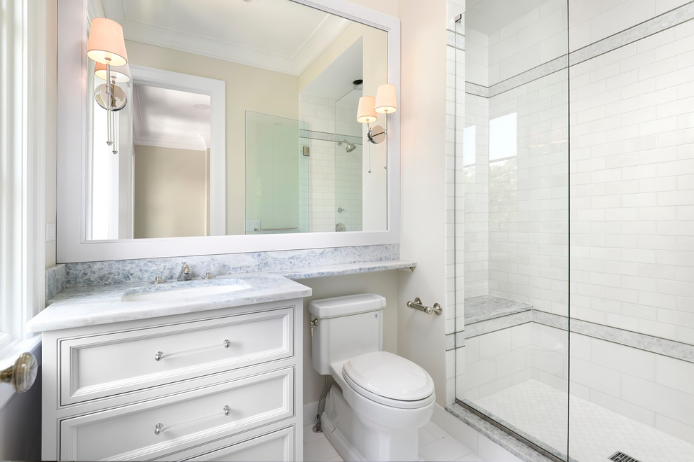 Example of a large transitional white tile and stone tile marble floor alcove shower design in Chicago with an undermount sink, beaded inset cabinets, gray cabinets, marble countertops, a one-piece toilet and white walls