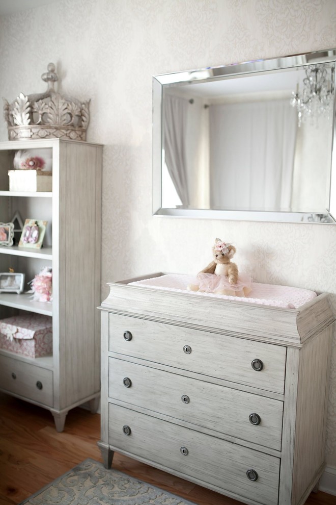 Photo of a mid-sized contemporary nursery for girls in New York with grey walls and dark hardwood floors.