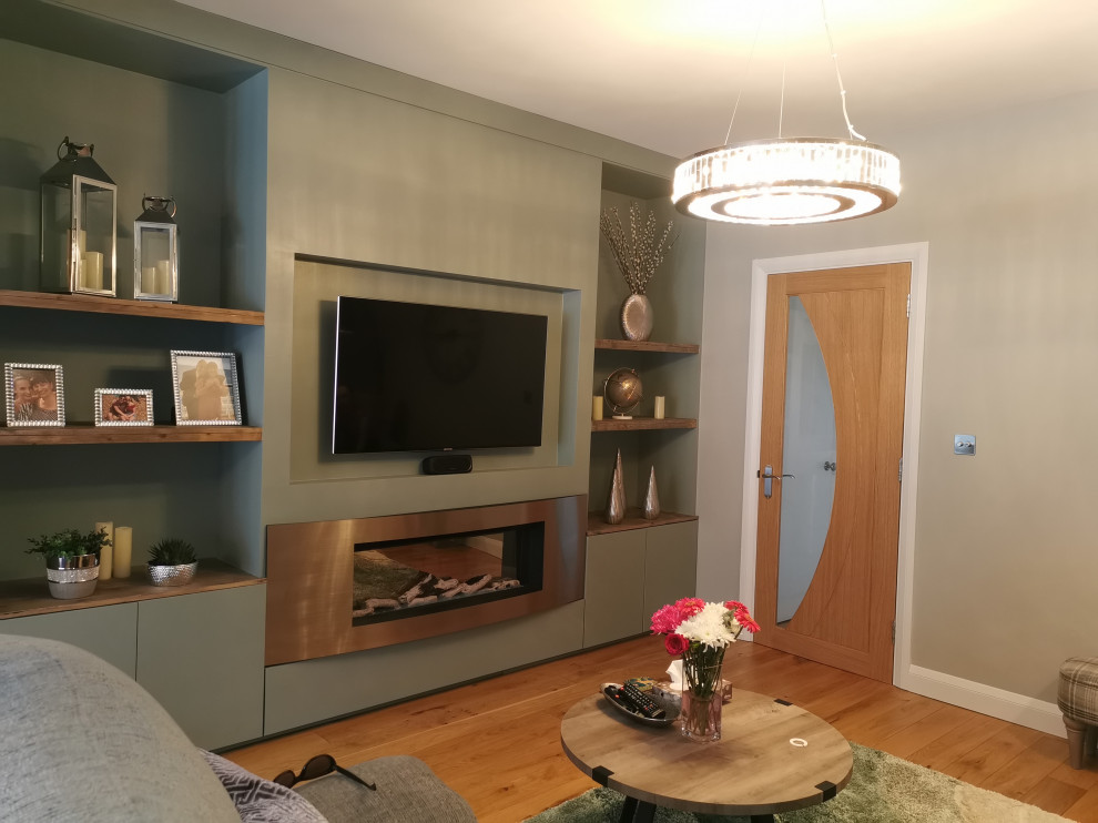 Mittelgroßes, Abgetrenntes Modernes Wohnzimmer mit grauer Wandfarbe, Laminat, Hängekamin, Kaminumrandung aus Metall, Multimediawand und Tapetenwänden in Essex