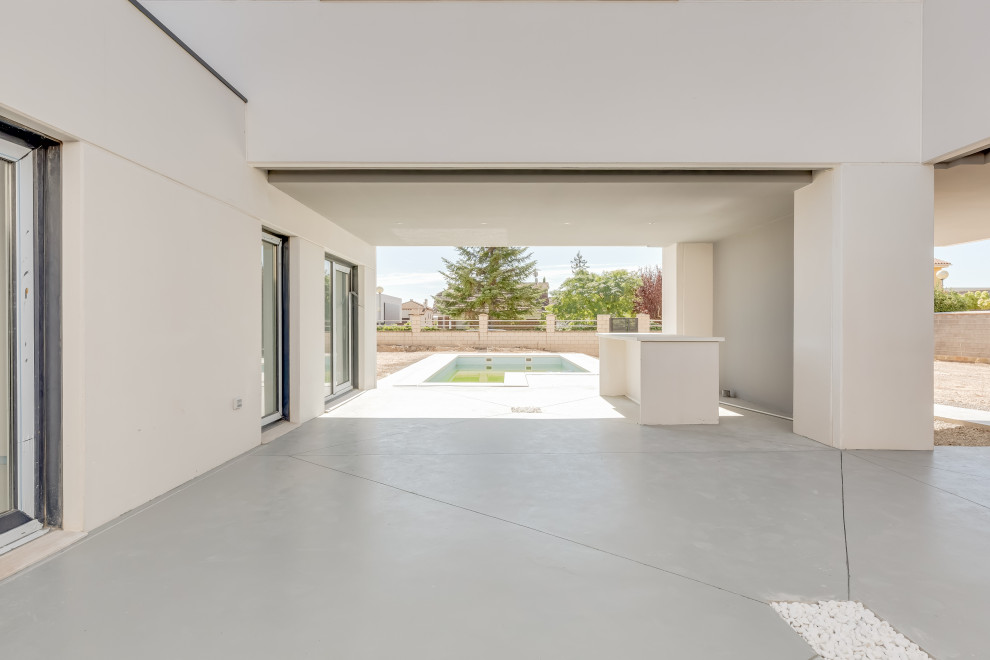 Imagen de patio contemporáneo de tamaño medio en patio delantero con losas de hormigón