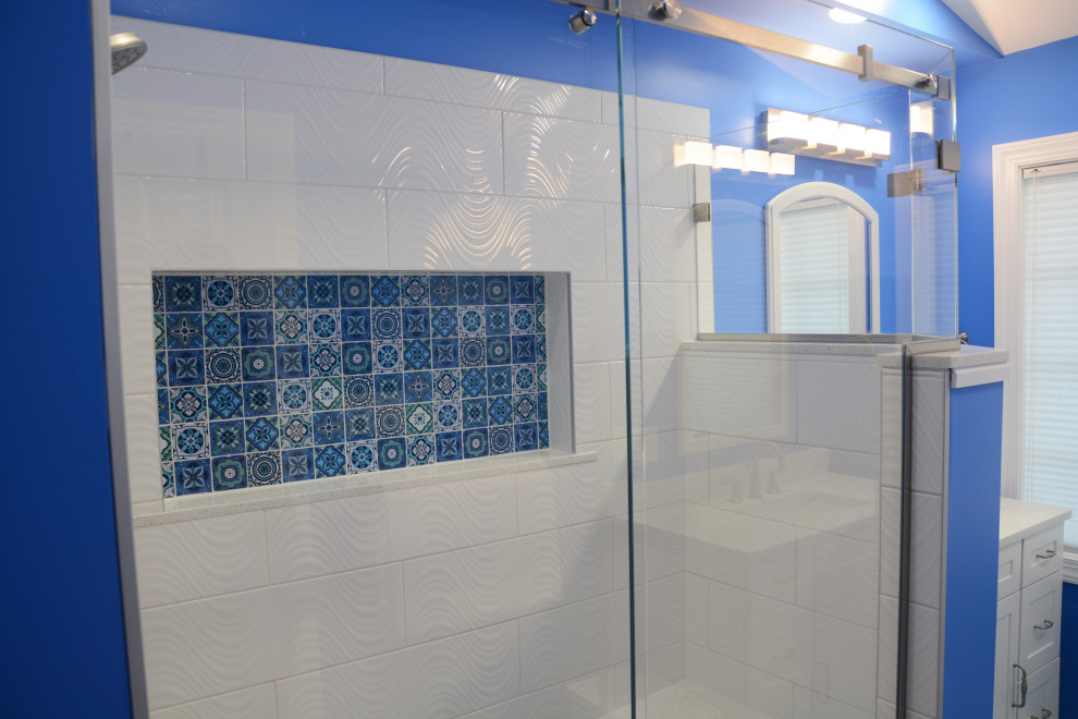 Foto på ett mellanstort maritimt vit en-suite badrum, med luckor med infälld panel, vita skåp, en hörndusch, vit kakel, blå väggar, ett undermonterad handfat, bänkskiva i kvarts, grått golv och dusch med gångjärnsdörr