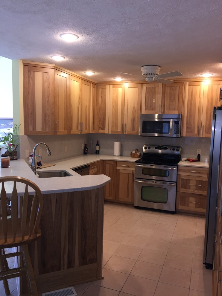 Example of a small transitional u-shaped porcelain tile and beige floor eat-in kitchen design in Omaha with an undermount sink, shaker cabinets, medium tone wood cabinets, quartz countertops, white backsplash, stainless steel appliances, a peninsula and white countertops